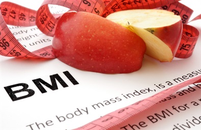Papper med text om BMI, ett skivat äpple och ett rött måttband