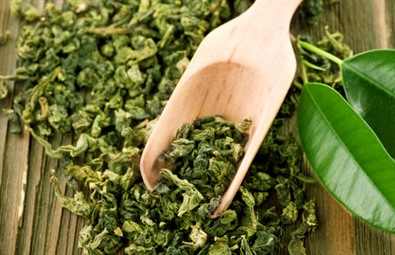 Gröna teblad på träsked