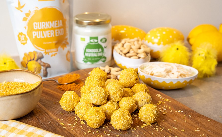 Vackert gula raw citronbollar uppdukade p� en sk�rbr�da av tr�, omgiven av p�sk�gg och ingredienser.