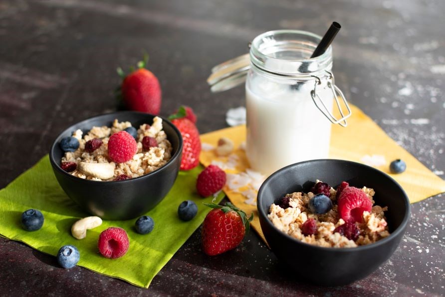  Fin uppdukning av yoghurt med granola och frska br och en glasflaska med mjlk.