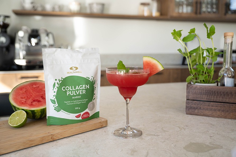 Ett glas fyllt med en mocktail tillsammans med Healthwell Collagen Pulver med smak av vattenmelon.