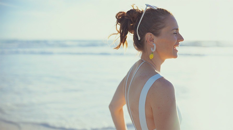 En kvinna st�r p� stranden. 