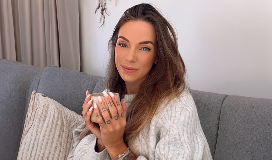 Linda sitter i sin soffa med en v�rmande kopp te i handen. 