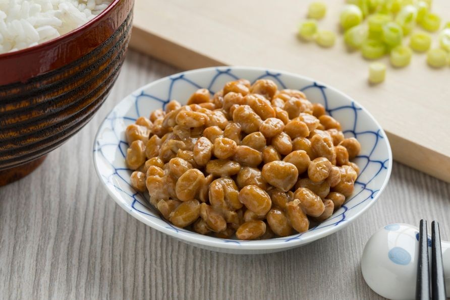 Natto � fermenterade sojab�nor serverade i en japansk sk�l med ris och hackad salladsl�k bredvid.